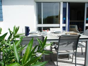 a table and chairs on a patio with plants at Holiday Home TY Greg by Interhome in Crozon