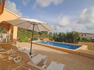 une terrasse avec des chaises et un parasol ainsi qu'une piscine dans l'établissement Holiday Home Roque by Interhome, à Calp