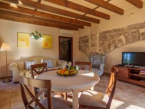 sala de estar con mesa, sillas y TV en Apartment Agroturismo Roqueta - MDS102 by Interhome, en Maria de la Salut