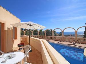 un patio con mesa, sombrilla y piscina en Apartment Canuta Baja 7 by Interhome en Calpe