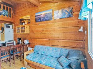 Holiday Home Porokaarre nr 14 by Interhome في روكا: غرفة معيشة مع أريكة زرقاء ومطبخ