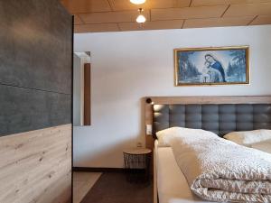 sypialnia z łóżkiem i obrazem na ścianie w obiekcie Apartment Alpenliebe-3 by Interhome w mieście Kappl