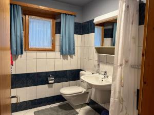 a bathroom with a toilet and a sink at Apartment Deli by Interhome in Alvaneu