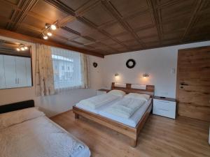 sypialnia z dwoma łóżkami i drewnianym sufitem w obiekcie Apartment Alpenliebe-3 by Interhome w mieście Kappl