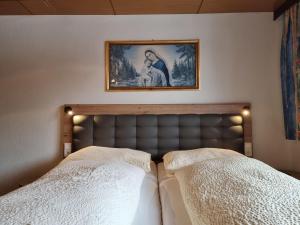 łóżko z 2 białymi poduszkami i zdjęciem na ścianie w obiekcie Apartment Alpenliebe-3 by Interhome w mieście Kappl