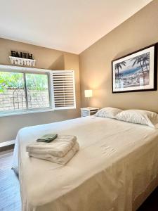 una camera da letto con un grande letto bianco e una finestra di Casa Oasis/Pool & Jacuzzi/4 Bedroom/ Wi-Fi a Camarillo