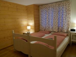 1 Schlafzimmer mit 2 Betten in einem Holzzimmer in der Unterkunft Holiday Home Chalet Ahornen by Interhome in Grindelwald