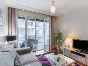 uma sala de estar com um sofá e uma televisão em Apartment Héraclès by Interhome em Nice