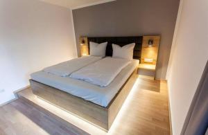 1 dormitorio con 1 cama con sábanas y almohadas blancas en The Room, en Regensburg
