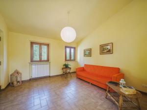 sala de estar con sofá rojo y mesa en Apartment Ca` del Lovi-1 by Interhome, en Chiatri