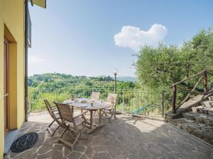 una mesa y sillas en un patio con vistas en Apartment Ca` del Lovi-3 by Interhome, en Chiatri