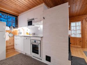 ユッラスヤルヴィにあるHoliday Home Kaltiotievantie 2 mökki 3 by Interhomeの木製の天井、白い家電製品付きのキッチン