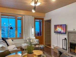a living room with a couch and a fireplace at Holiday Home Ruka sunhill by Interhome in Ruka