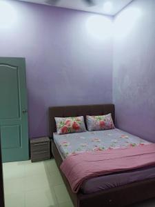 a bedroom with a bed with flowers on it at Fidaiy Homestay in Teronoh