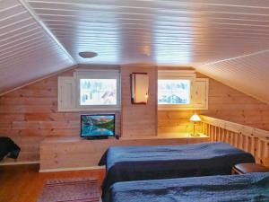 ein Schlafzimmer mit zwei Betten und einem Fernseher in einer Kabine in der Unterkunft Holiday Home Hovitahko a 1 by Interhome in Tahkovuori + 8 Fotos