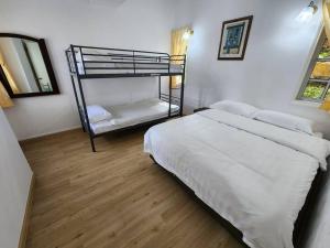 1 dormitorio con 1 cama y 1 litera en Little England B3, en Bukit Fraser