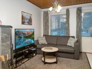 ein Wohnzimmer mit Couch und Flachbildfernseher in der Unterkunft Holiday Home Alppitalo punatähti 7 apt 2 by Interhome in Tahkovuori
