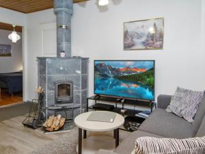 ein Wohnzimmer mit einem Kamin und einem großen TV in der Unterkunft Holiday Home Alppitalo punatähti 7 apt 2 by Interhome in Tahkovuori