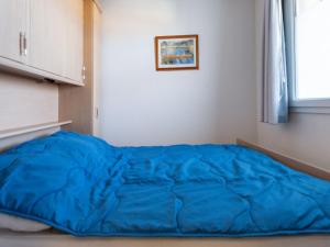 カップ・ダグドにあるApartment Le Sunset-Cap Sud-14 by Interhomeの窓付きの客室で、大きな青いベッド1台を利用できます。