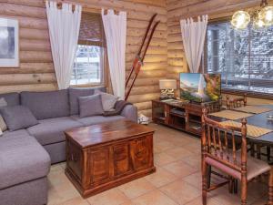 ein Wohnzimmer mit Sofa und Tisch in der Unterkunft Holiday Home Tahkon tikka by Interhome in Tahkovuori