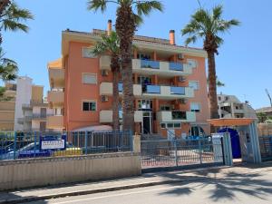 un edificio con palmeras delante en Apartment Azzurra by Interhome, en Porto dʼAscoli