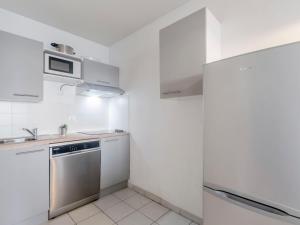 cocina blanca con fregadero y nevera en Apartment L'Open-2 by Interhome, en Fréjus