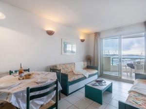 a living room with a table and a couch at Apartment L'Open-2 by Interhome in Fréjus