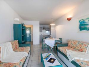 a living room with couches and a table and a kitchen at Apartment L'Open-2 by Interhome in Fréjus +25 photos