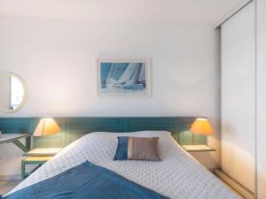 1 dormitorio con 1 cama, 2 lámparas y espejo en Apartment L'Open-2 by Interhome, en Fréjus