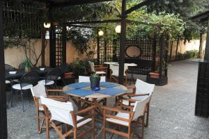 a patio with tables and chairs under a pergola at Villa Orion Hotel in Athens