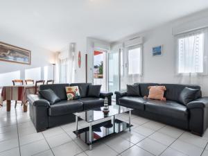uma sala de estar com dois sofás pretos e uma mesa em Apartment Argia Eder by Interhome em Saint-Jean-de-Luz