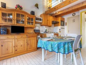 サン・シプリアン・プラージュにあるHoliday Home Le Hameau du Port by Interhomeのキッチン(テーブル、椅子、テレビ付)