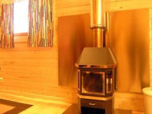 a kitchen with a stove in the corner of a room at Holiday Home Uisku by Interhome in Punkalaidun +16 photos