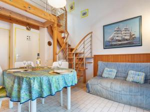 サン・シプリアン・プラージュにあるHoliday Home Le Hameau du Port by Interhomeのリビングルーム(テーブル付)、壁にヨットが備わります。