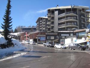 a city street with cars parked in front of a building at Apartment Emeraudes by Interhome in Anzère