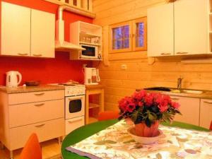 eine Küche mit einem Tisch und einer Blumenvase darauf in der Unterkunft Holiday Home Uisku by Interhome in Punkalaidun