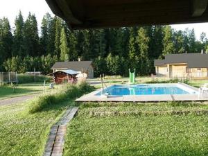 einen Hinterhof mit einem Pool im Gras in der Unterkunft Holiday Home Uisku by Interhome in Punkalaidun