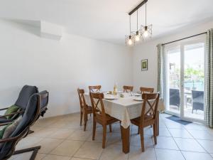 a dining room with a table and chairs at Holiday Home Les Lauriers by Interhome in Aigues-Mortes