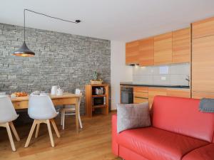 a living room with a red couch and a kitchen at Apartment Rosablanche E003A by Interhome in Siviez