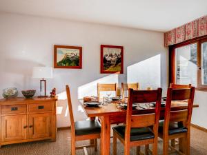 Apartment Fleurs des Alpes-1 by Interhome في سان جيرفيه ليه بان: غرفة طعام مع طاولة وكراسي خشبية