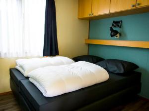 Una cama con dos almohadas encima. en Holiday Home Duinhoeve-1 by Interhome, en Udenhout
