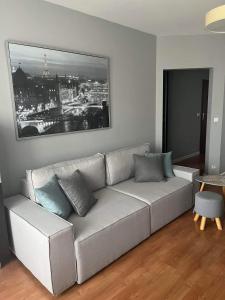 una sala de estar con un sofá con una foto en la pared en Klimatyzacja - przy centrum Onkologii klinice Novum dla pary bądź 4 osób, en Varsovia