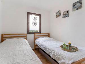 two twin beds in a room with a window at Apartment Santa Monica 1 by Interhome in Cap d'Agde