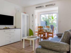 a living room with a tv and a couch and a table at Apartment Santa Monica 1 by Interhome in Cap d'Agde