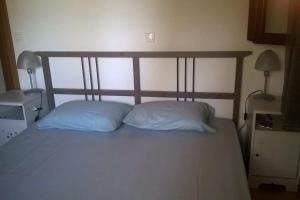 1 dormitorio con 1 cama con 2 almohadas y 2 lámparas en Villa Evelina en Kalamata