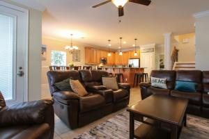 a living room with leather furniture and a kitchen at Amazing 4 Bedroom Vacation Home in The Villages of Crystal Lakes in Destin