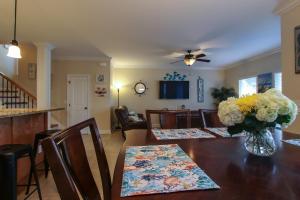 a dining room with a table with a vase of flowers at Amazing 4 Bedroom Vacation Home in The Villages of Crystal Lakes in Destin