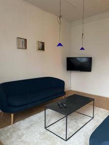 a living room with a blue couch and a coffee table at OnlySleep Femern in Holeby