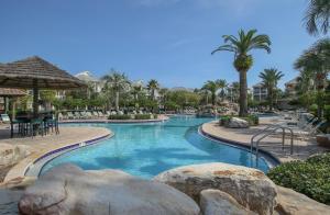 a swimming pool at a resort with palm trees at Amazing 4 Bedroom Vacation Home in The Villages of Crystal Lakes in Destin