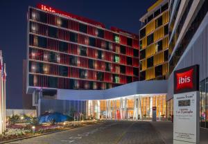 a lit up building with arets sign in front of it at ibis Doha in Doha
